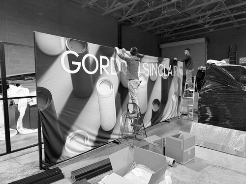 Crew applying Gordon Sinclair graphics to a curved exhibit wall