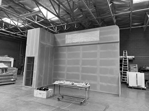 Curved exhibit wall with inset display panels before finishing