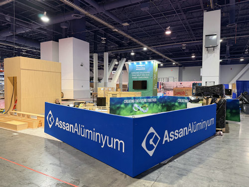 Branded blue exhibit counter and wall graphics on the show floor