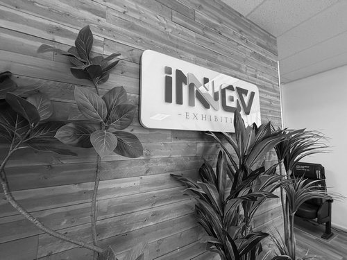 Illuminated Inkley Audio sign mounted on a wood feature wall