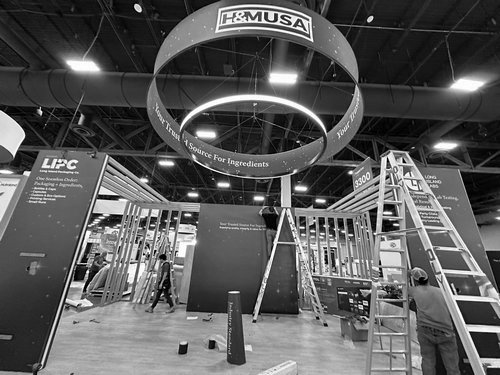 H&M USA hanging sign installed above the booth during setup