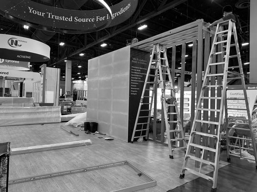 Exhibit walls being assembled beneath the H&M USA hanging sign