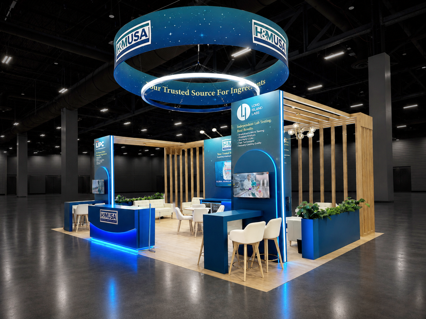 Blue custom island trade show booth with suspended signage and branded meeting space