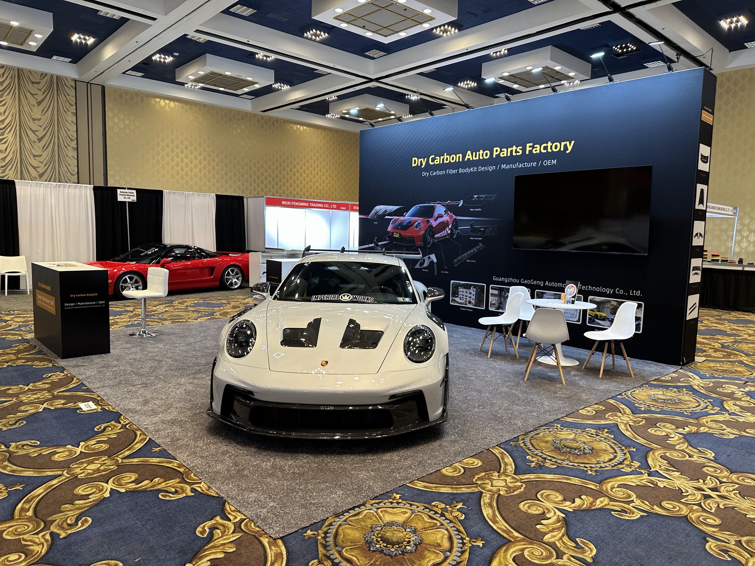 Dry Carbon vehicle display with two cars and an aisle-facing product wall at SEMA