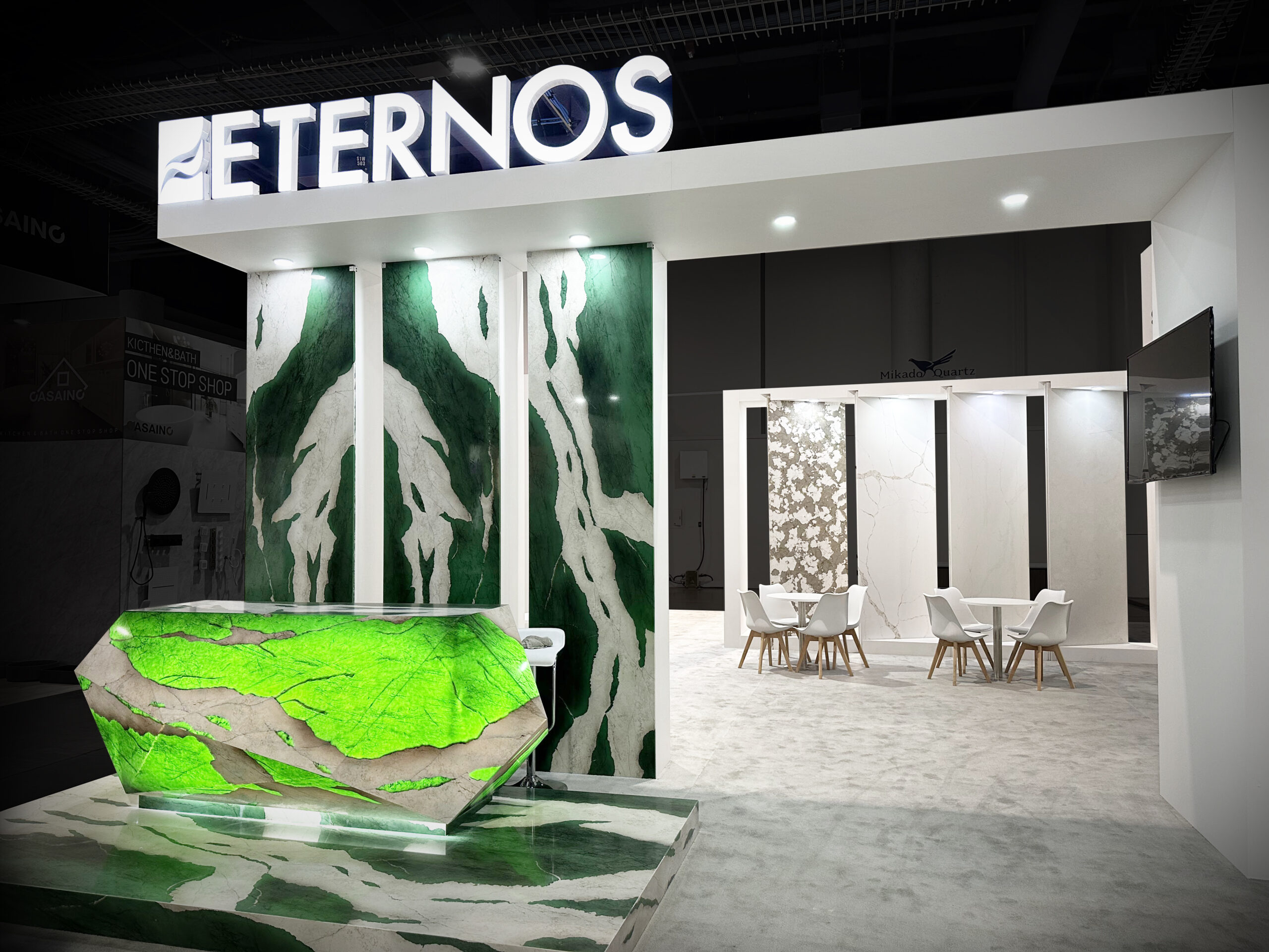 Eternos custom exhibit with illuminated green stone feature and meeting area