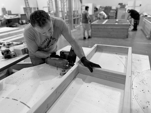 Fabricator assembling a framed exhibit component
