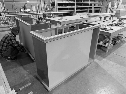 Fabricator fitting walls to a custom exhibit counter