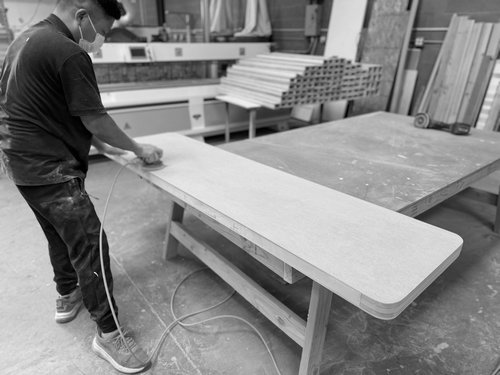 Fabricator sanding a rounded exhibit countertop