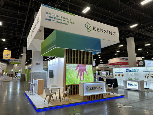 Overhead branded exhibit identifier installed above a show-floor booth