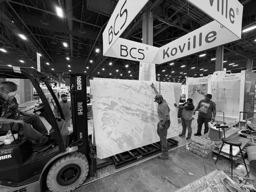 Crew handling booth materials and installation equipment