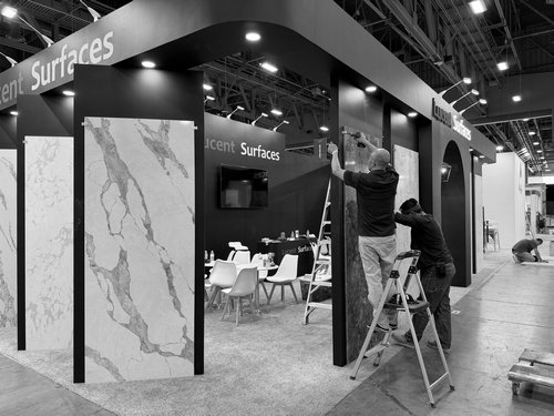 Forklift and crew handling large booth components at a trade show