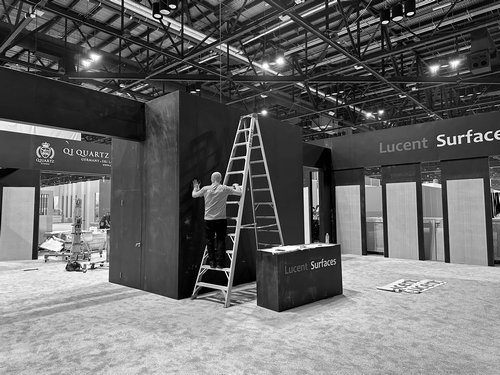 Trade show booth installation with workers completing a branded exhibit
