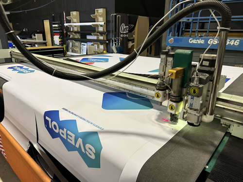 Precision machine cutting branded graphic components in the workshop